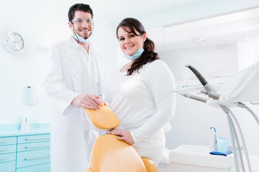 Dentist and nurse in their clinic as team