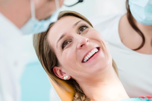 Woman with healthy smile at dentist after successful treatment