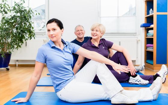 Physio doing kinesiotherapy with senior patients