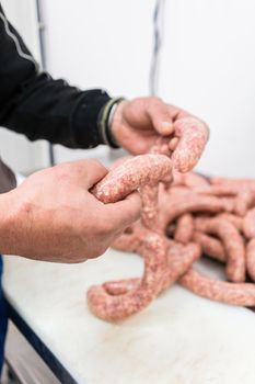 Butcher making sausages in meat factory