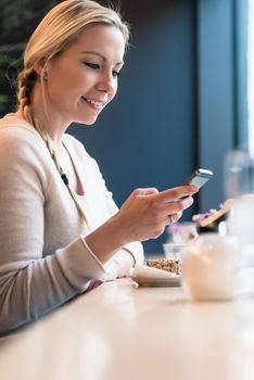 Woman using her phone in a train cabin checking her social media feed