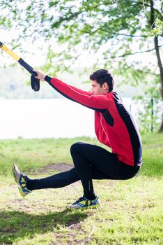 Man doing fitness leg training with slings