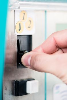 Close-up of male hand using coin-operated machine at self-service car wash