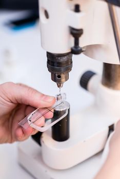 Man polishing spectacle glasses in optical workshop