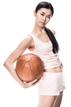 Young fit Asian woman looking at camera while holding brown medicine ball