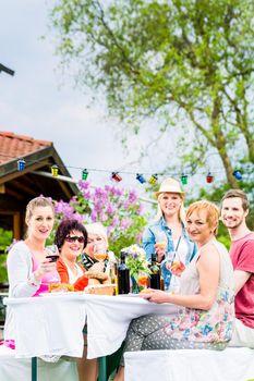 Friends eating bbq sausage and meat at garden or grill party