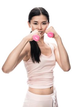 Portrait of young determined woman holding small dumbbells in combat position