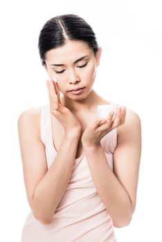 Beautiful young Asian woman applying facial moisturizer cream for sensitive skin care