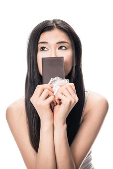 Portrait of young Asian woman looking up while holding a chocolate bar