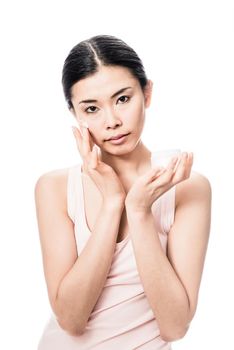 Beautiful young Asian woman applying facial moisturizer cream for sensitive skin care