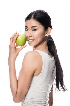 Happy Asian young woman looking at camera while holding a green apple against white background
