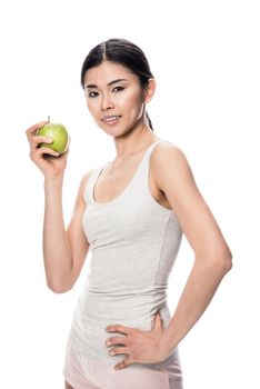 Happy Asian young woman looking at camera, while holding a green apple against white background