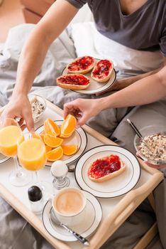 Close-up of romantic healthy breakfast with orange juice, jam, cereals and coffee