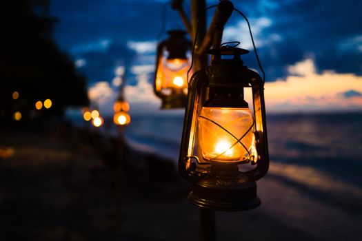 Sunset on an island beach with lanterns illuminating the romantic scene