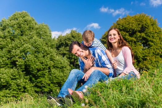 Family having fun sitting in the green grass