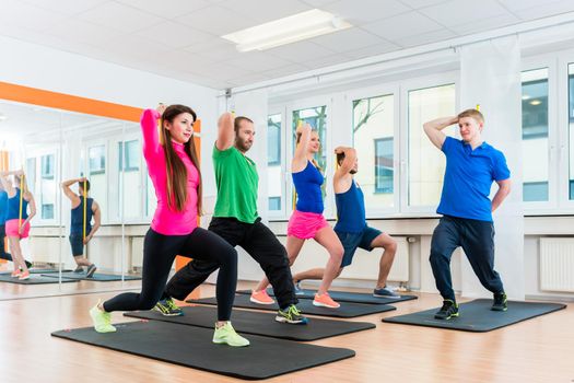 Young athletes doing gymnastics in health club gym