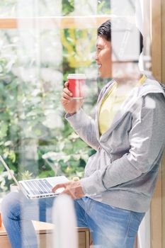 Young man day dreaming while drinking a coffee during break in the office or at the university