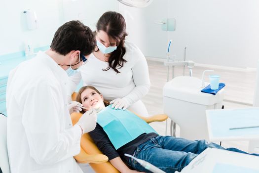 Dentist trearing child in his surgery, there is no need to drill a tooth