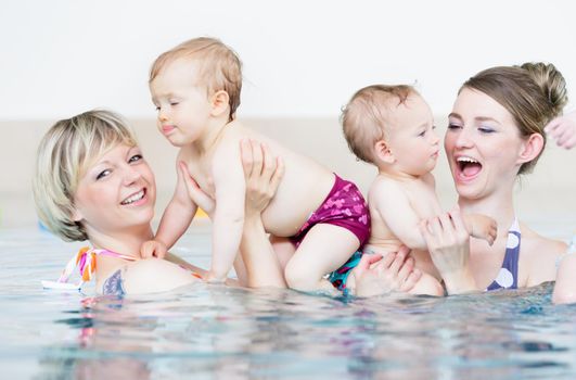 Mothers and their little babies having fun at infant swimming class