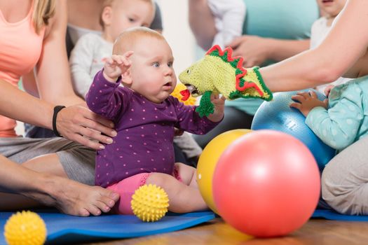 Young women in mother and child group playing with their baby kids