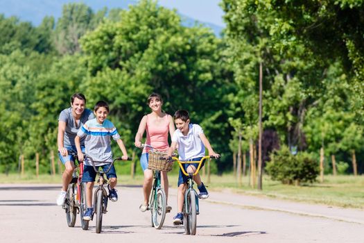 Family of four on bike tour in summer