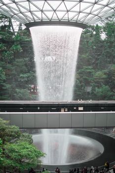 SINGAPORE - 21 DEC 2019: Rain Vortex the largest indoor waterfall located in Jewel Changi Airport with MRT and Tourists.