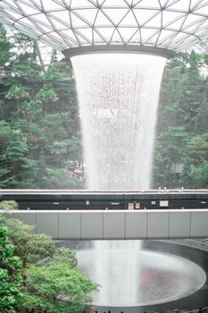 SINGAPORE - 21 DEC 2019: Rain Vortex the largest indoor waterfall located in Jewel Changi Airport with MRT and Tourists.