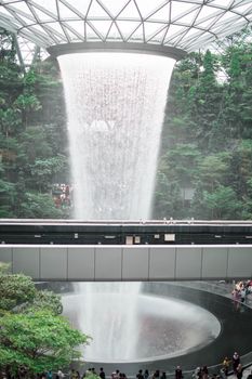 SINGAPORE - 21 DEC 2019: Rain Vortex the largest indoor waterfall located in Jewel Changi Airport with MRT and Tourists.