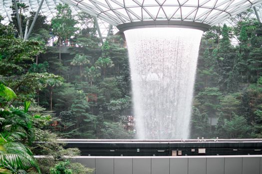 SINGAPORE - 21 DEC 2019: Rain Vortex the largest indoor waterfall located in Jewel Changi Airport with MRT and Tourists.