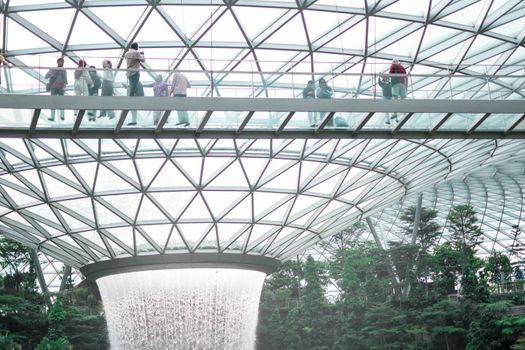 SINGAPORE - 21 DEC 2019: Rain Vortex the largest indoor waterfall located in Jewel Changi Airport with MRT and Tourists.