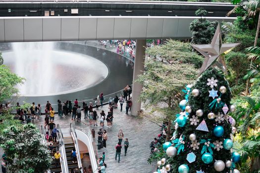 SINGAPORE - 21 DEC 2019: Tallest Christmas Tree located in Jewel Changi Airport with MRT and Tourists.