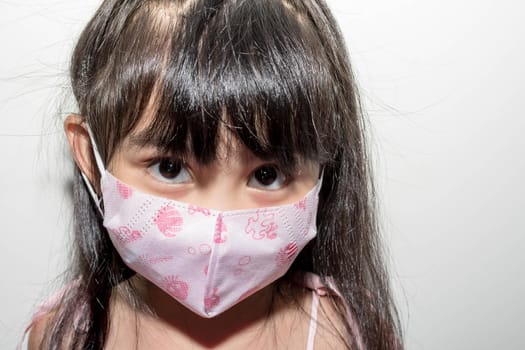 Asian female child wearing a mask to protect against the Corona virus that can spread through the air