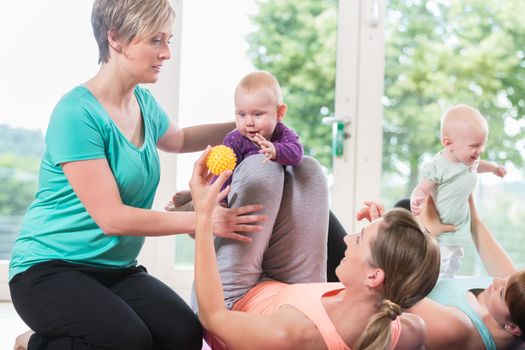 Women and their babies in mother-child gymnastic course practicing