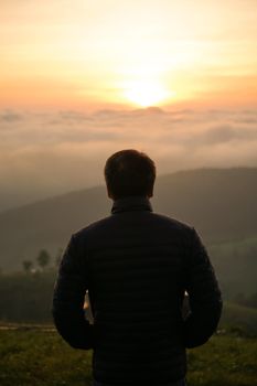 man watching sunrise alone at hilltop