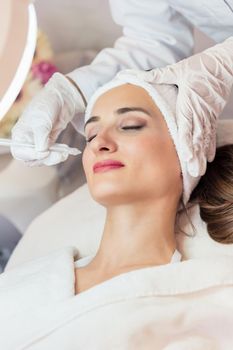 Beautiful woman relaxing during non-invasive facial treatment for rejuvenation in a contemporary beauty center with innovative equipment