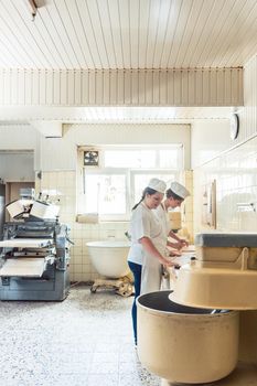 Wide view of bread production in bakery with two women working
