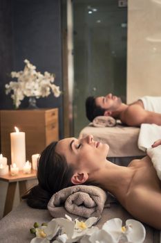 Young man and woman lying down on massage beds at Asian luxury spa and wellness center