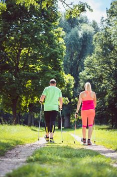 Couple of man and woman doing Nordic Walking for sport