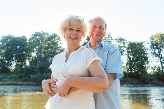 Low-angle side view portrait of a romantic senior couple in love enjoying a healthy and active lifestyle outdoors in summer