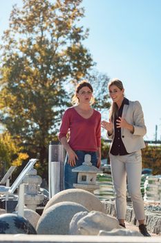 Two women in store selling nature stone for garden and home decoration