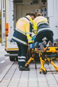 Paramedic on stretcher fighting for life of injured woman giving cardiac massage