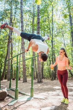 Sportive couple, woman and man, doing workout in outdoor gym