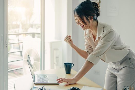 Excited Asian Businesswoman Celebrating Success At Workplace