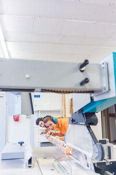 Man and woman carpenter cutting board working together