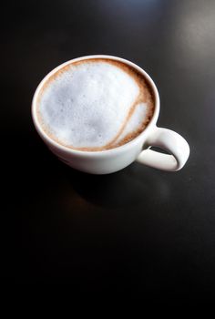 Hot milk coffee and soft froth in white ceramic cup