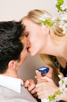 He is proposing, she looks as if she is considering a yes; focus on eyes