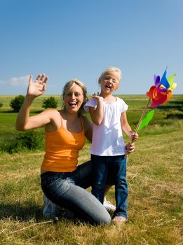 Mother and daughter with a pinwheel outdoors