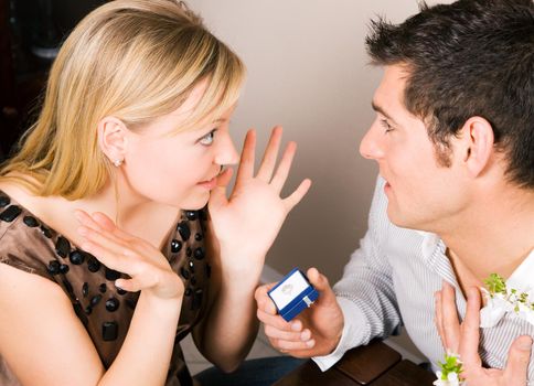 Man proposing to his (hopefully) future wife - she seems to be accepting; focus on eyes