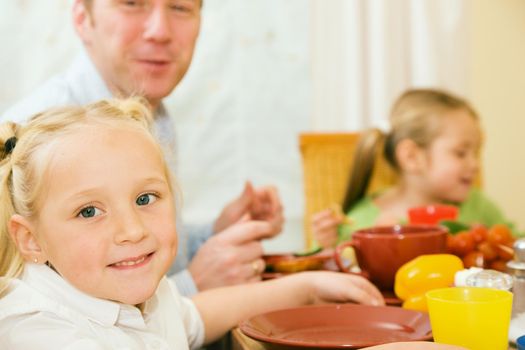 Family (Father and two Kids) having a lot of fun while eating breakfast