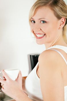 Gorgeous woman visibly enjoying a hot cup of coffee in the morning